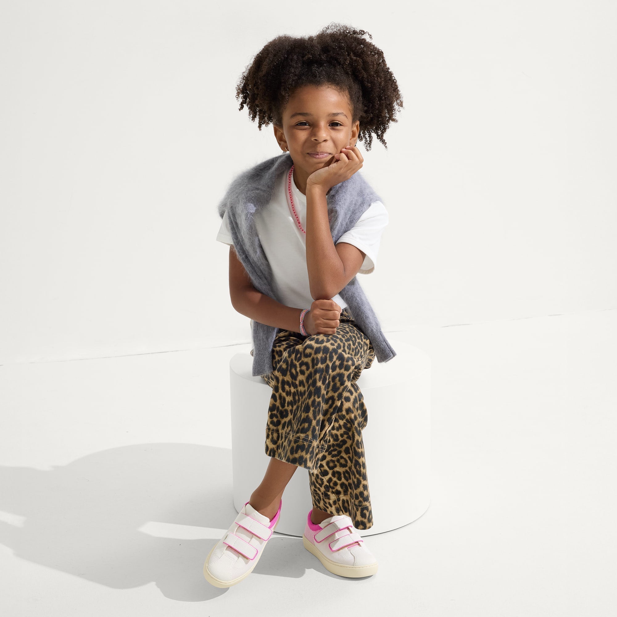 model | An alternate image of a child modeling The Kids Strap Sneaker in Pink Taffy. 