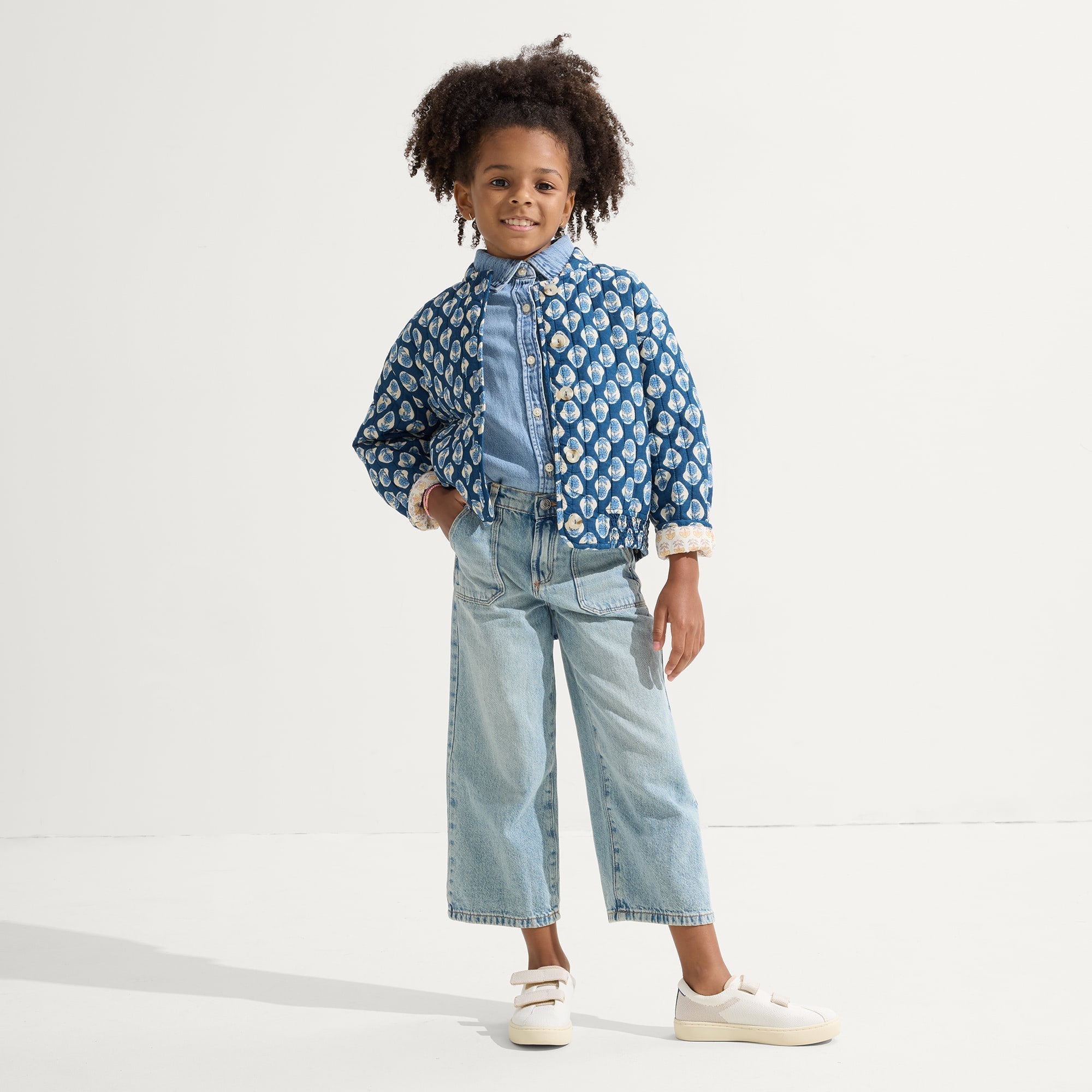 model | An alternate image of a child modeling The Kids Strap Sneaker in Vanilla Ice. 