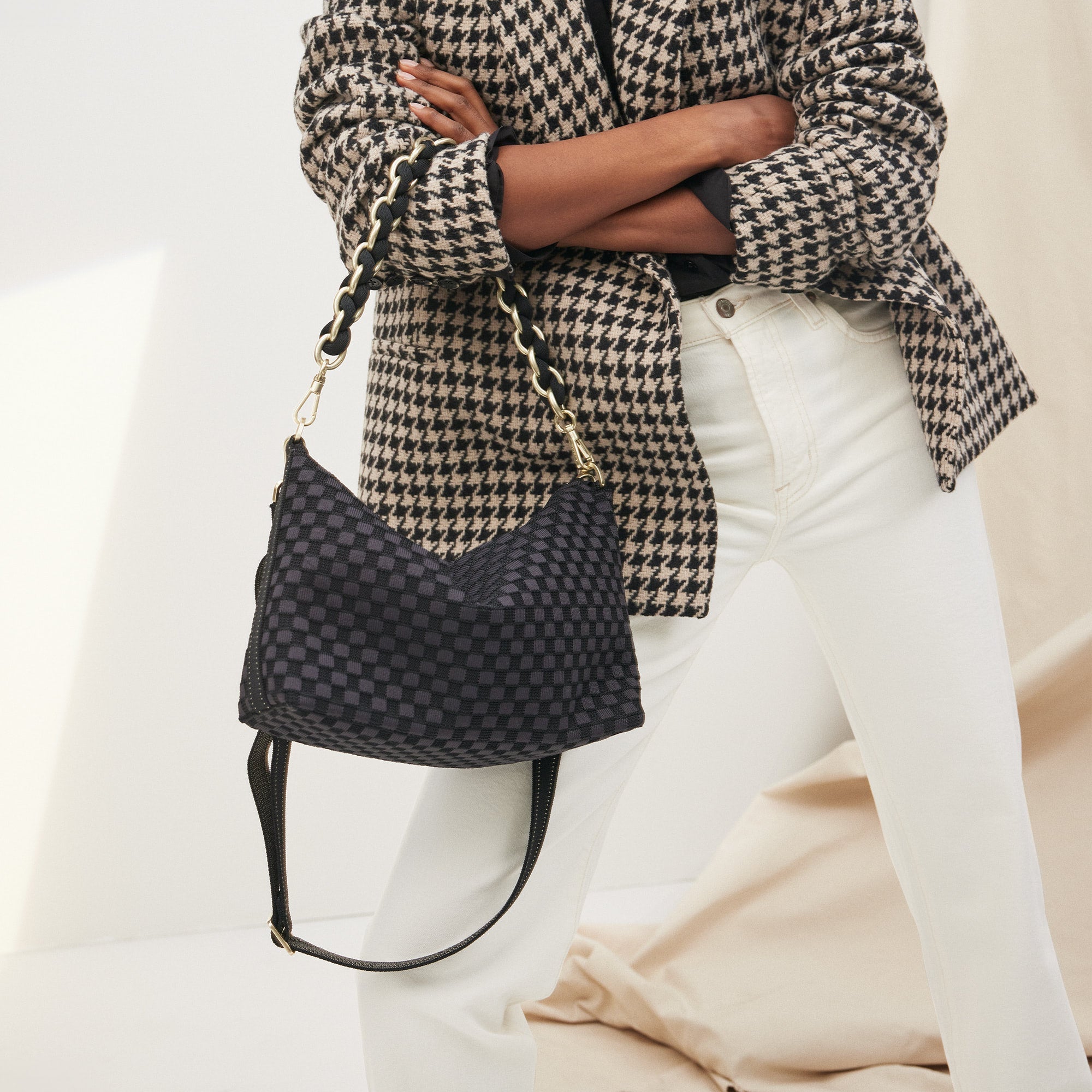 Overlay:: Shown with The Shoulder Strap (sold separately.) | Alt:: The Daily Crossbody in Black Sand paired with The Shoulder Strap in Black being carried by a model from a different angle.