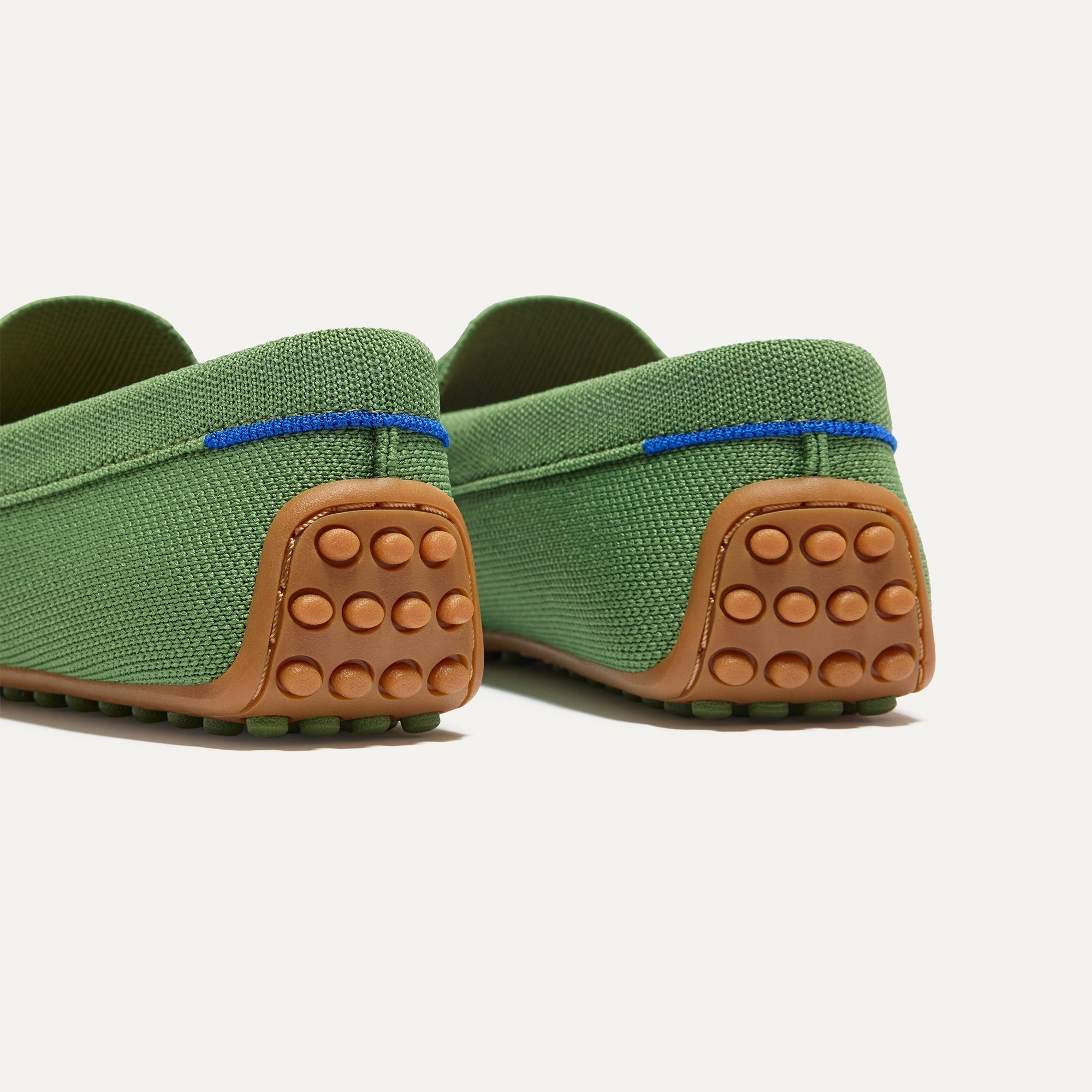 Close up of the heel of The Daily Driver in Sprout, with raised peg outsoles and Rothy's signature blue halo. 