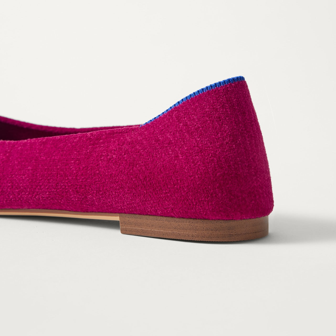 Close up of the heel of The Point III in ReVelvet Mulberry, with Rothy's signature blue halo. 