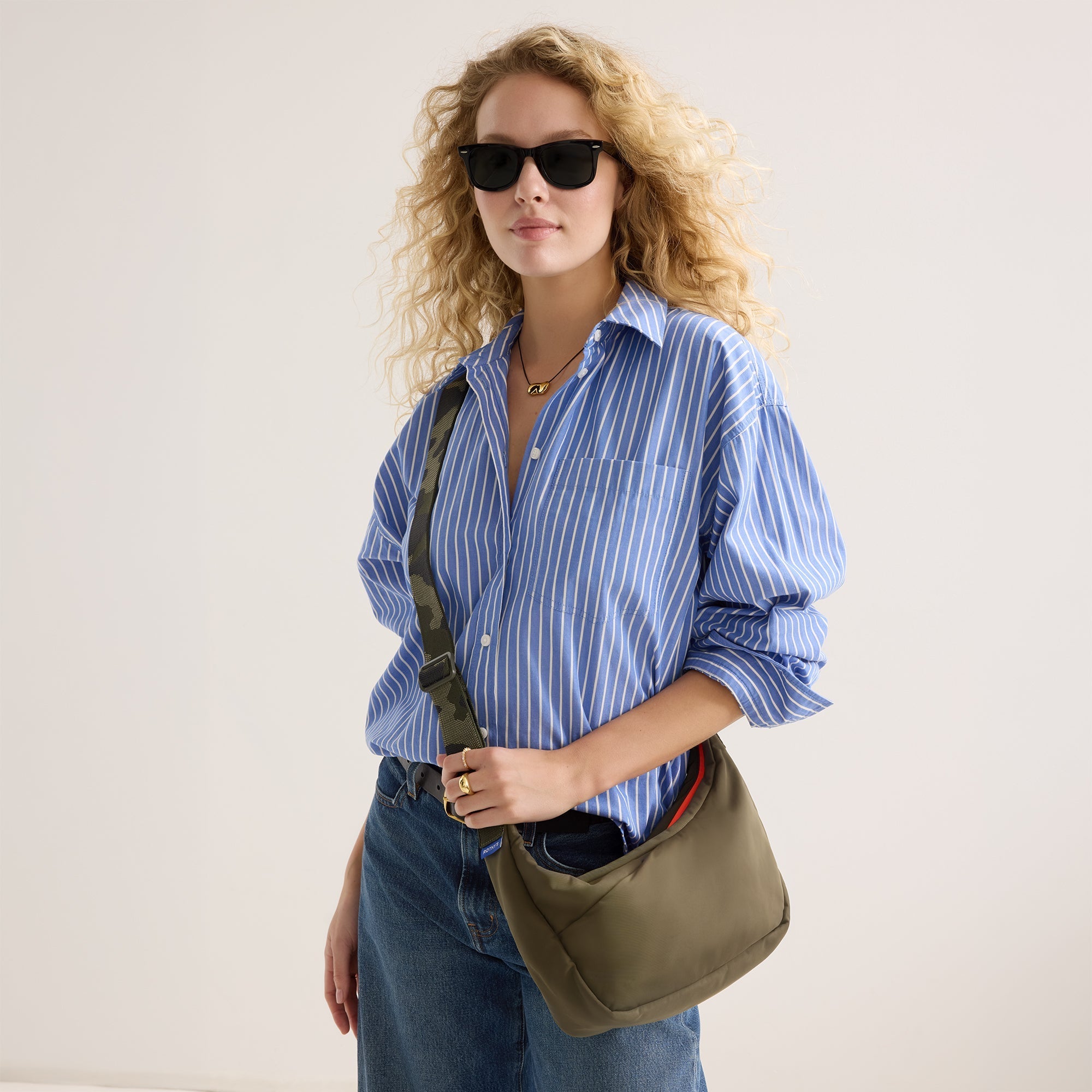 hover |Model carrying The Travel Sling in Forest shown from the front.