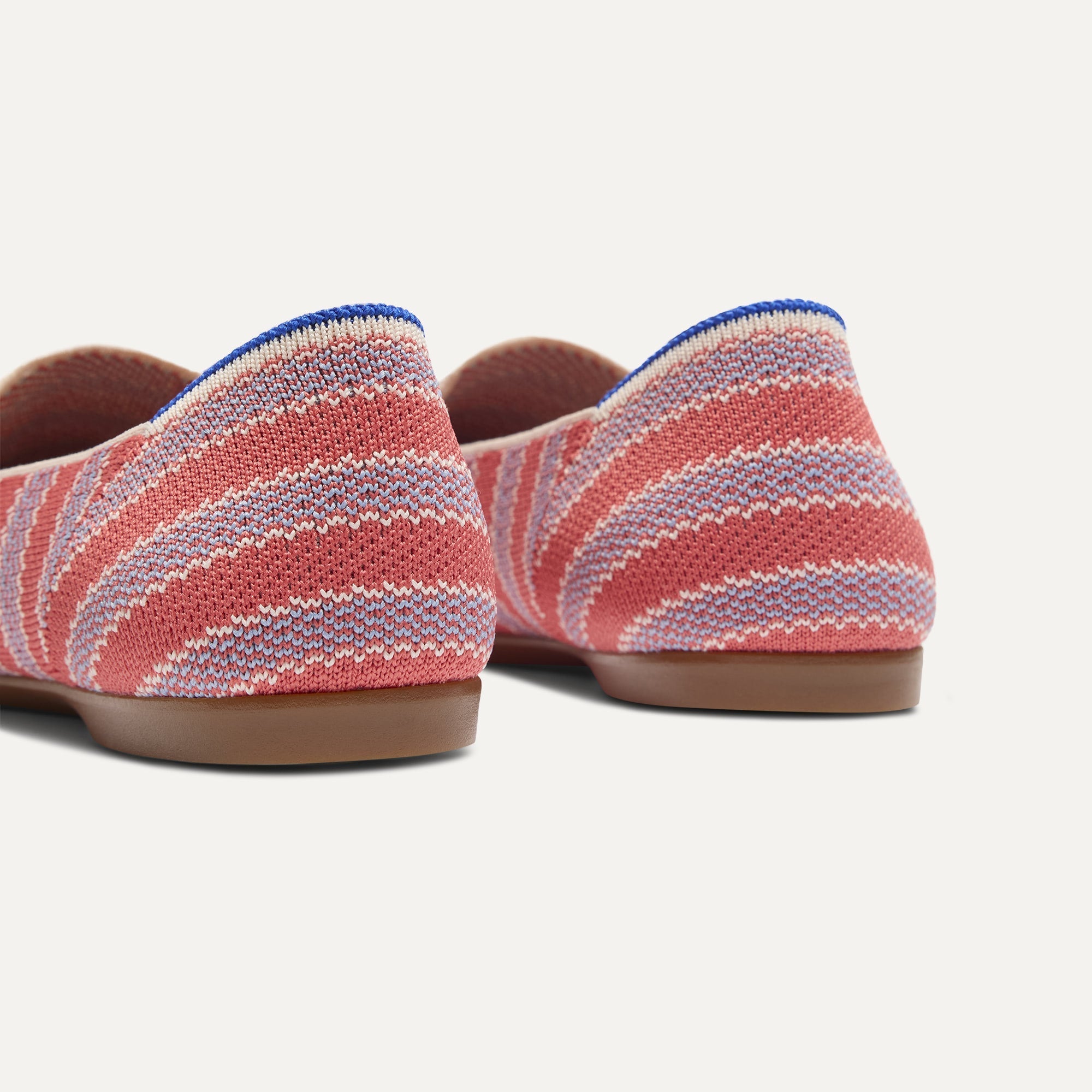 Close up of the heel of The Daily Loafer in Sunkiss Stripe, with raised peg outsoles and Rothy's signature blue halo. 