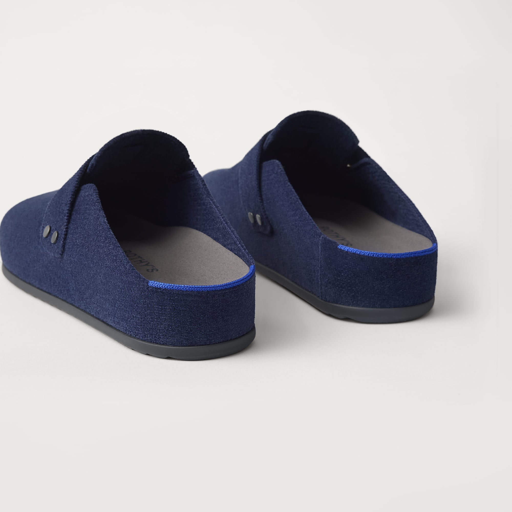 Close up of the heel of The Men's Clog in ReVelvet™ Deep Navy, with Rothy's signature blue halo. 